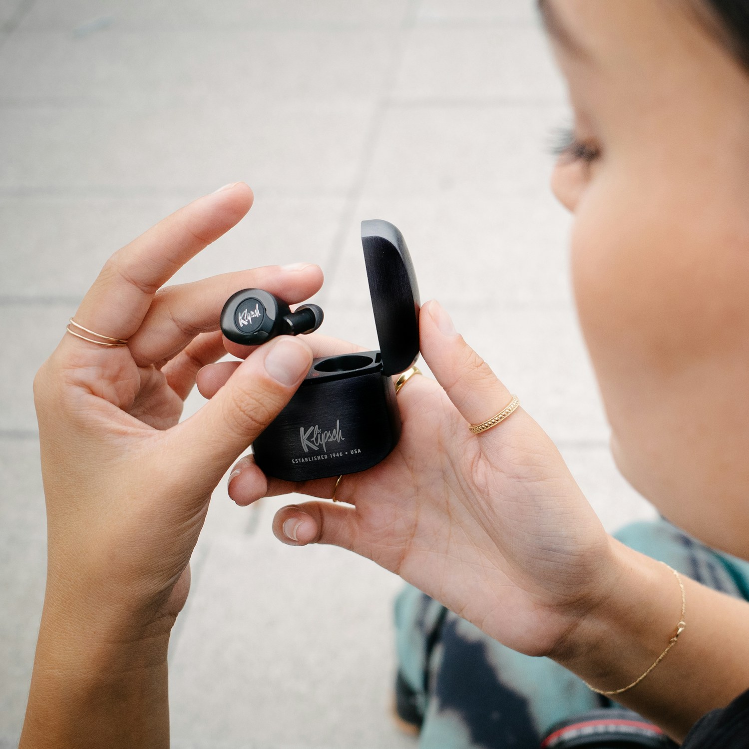Closeup of a woman looking at her Gunmetal Klipsch T5 II True Wireless ANC Earphones Mobile