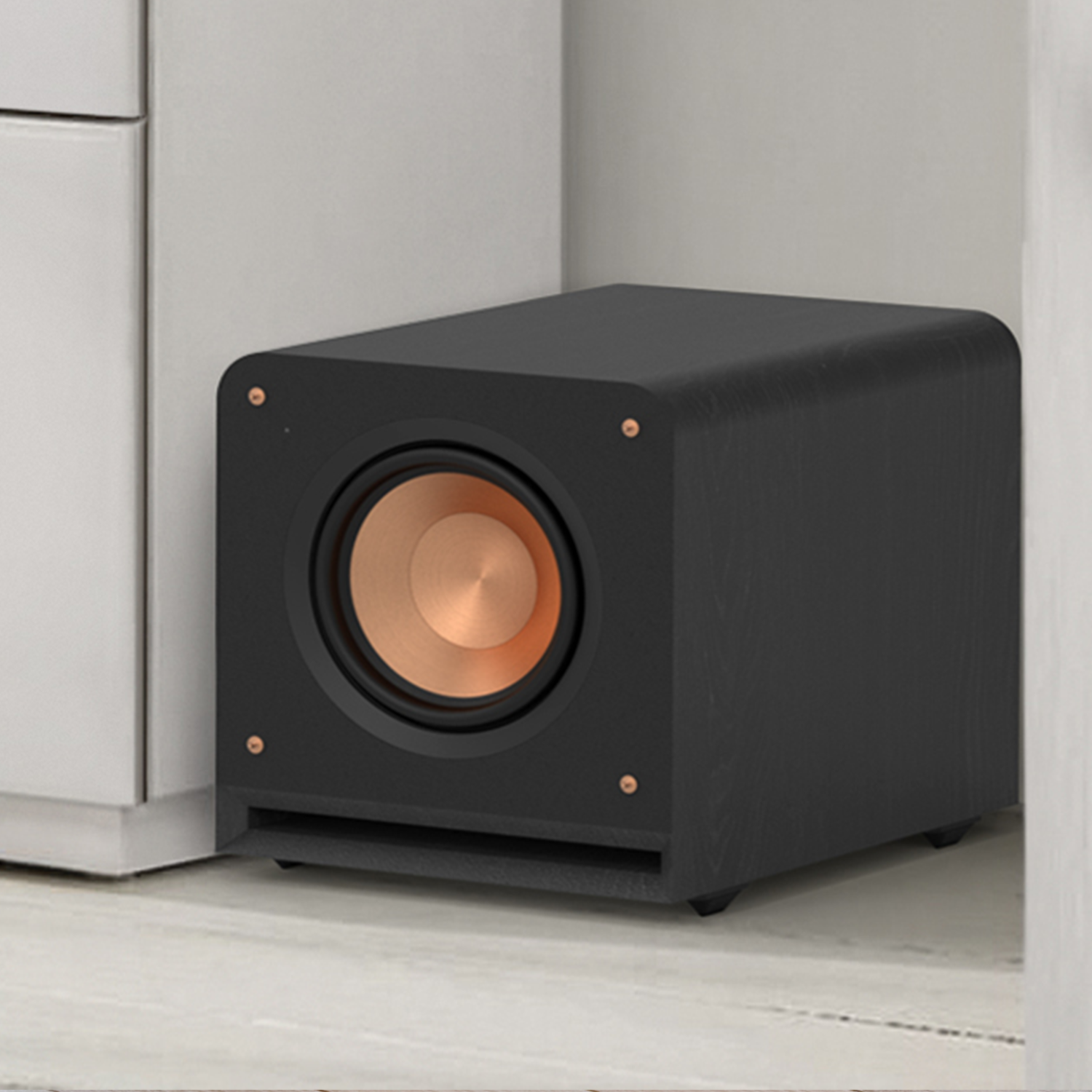 RP 1000 SW subwoofer with grille off against a white wall mobile