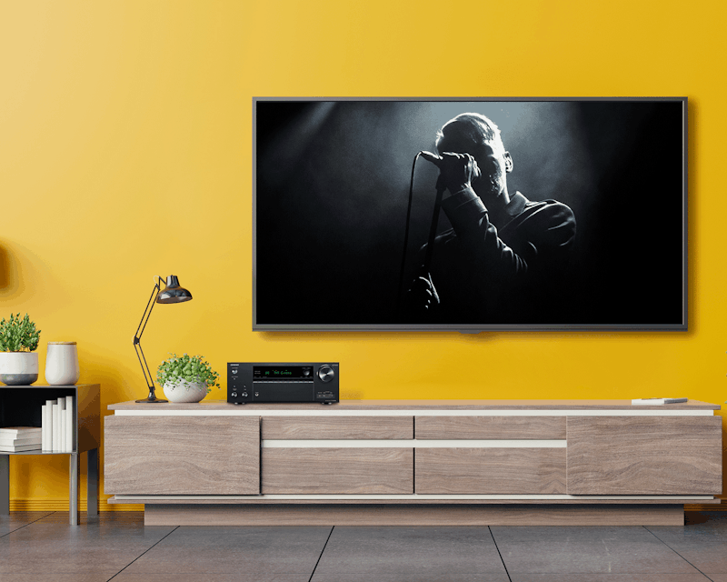 TX NR696 Playing Concert in Living Room with Yellow Wall 2000x1333